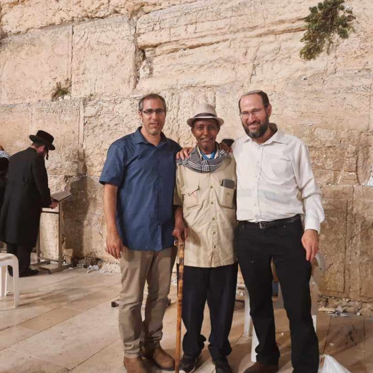 שלושה אנשים והכותל המערבי ברקע