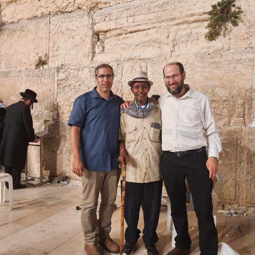 שלושה אנשים והכותל המערבי ברקע