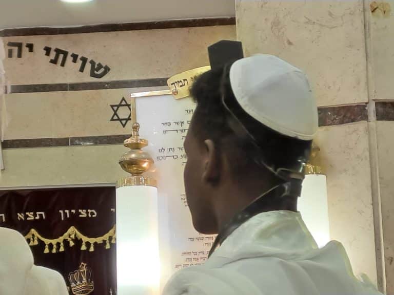 אדם עם כיפה ותפילין בתוך הבית הכנסת
